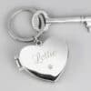 Heart-shaped silver paw print dog memorial keyring personalised with a dog's name and two photos